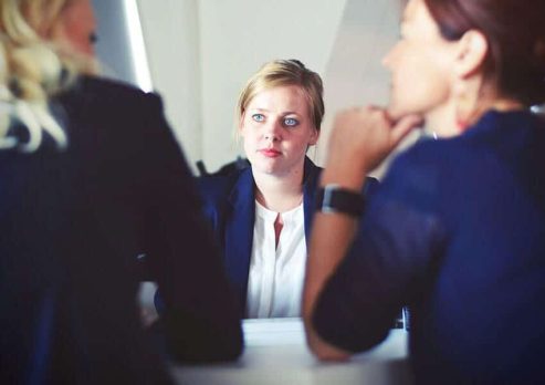 three-women-sitting-beside-table
